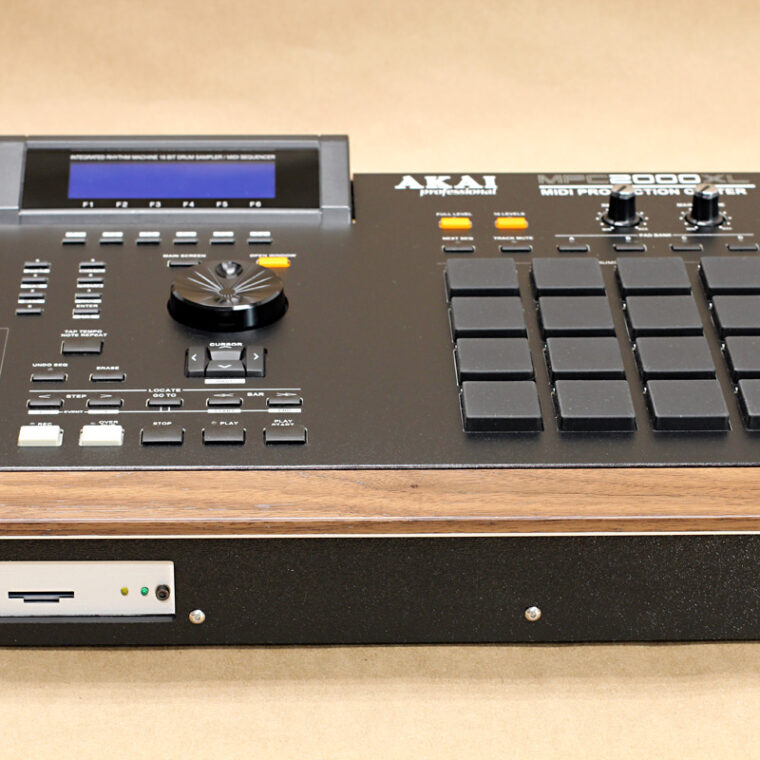 Custom modular Akai MPC 2000XL with black ABS bezel, hardwood wrist rest and hot swap card reader, on craft paper background.